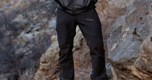 Person wearing black pants and boots standing on rocky terrain
